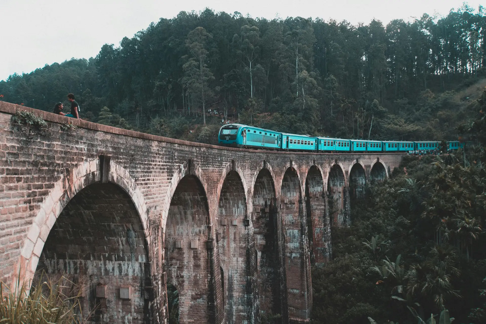 Ett blått tåg korsar Nine Arches-bron nära Ella